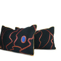 Detailed close up of pair of abstract navy decorative lumbar pillow with magenta lines, cobalt blue accents and metallic gold cord. Hand-sewn in Charlotte NC by Liz Saintsing.