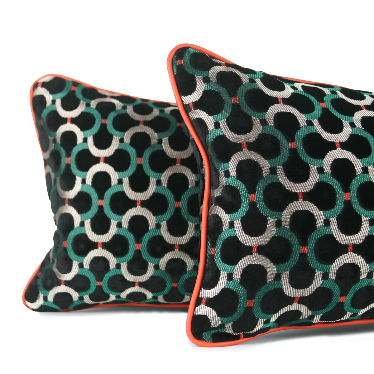 Detailed close up of black velvet decorative lumbar pillows with emerald green and silver geometric pattern and bright orange leather contrast welt. Hand-sewn in Charlotte NC by Liz Saintsing.